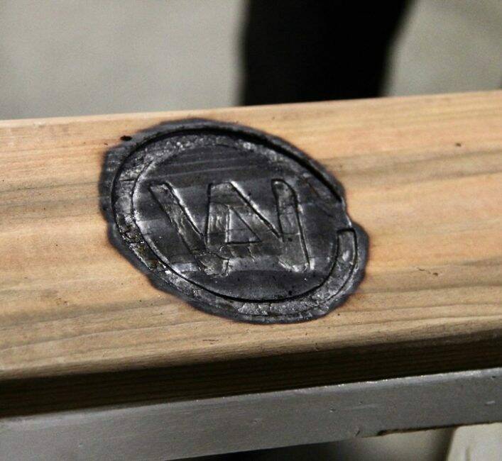 The logo of the Canadian Western Agribition that has been burned into a piece of wood using a branding iron.