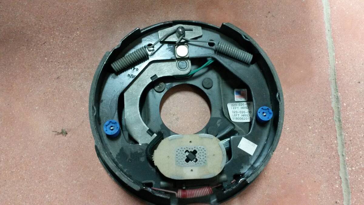 A look at the inside of a trailer's wheel hub showing springs and, at the bottom, an oval-shaped magnet.