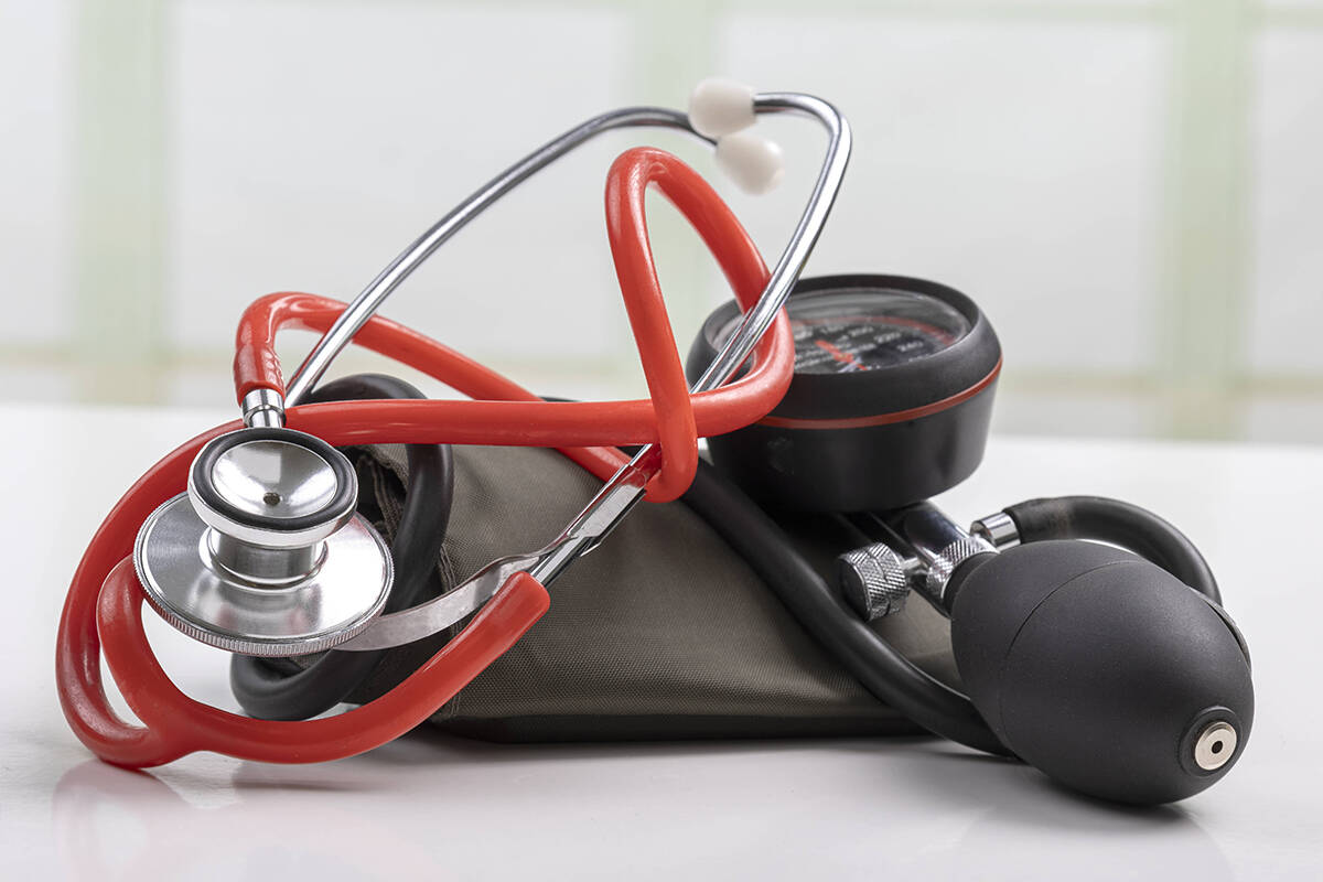 A stethoscope and a blood pressure cuff sit on a white surface.