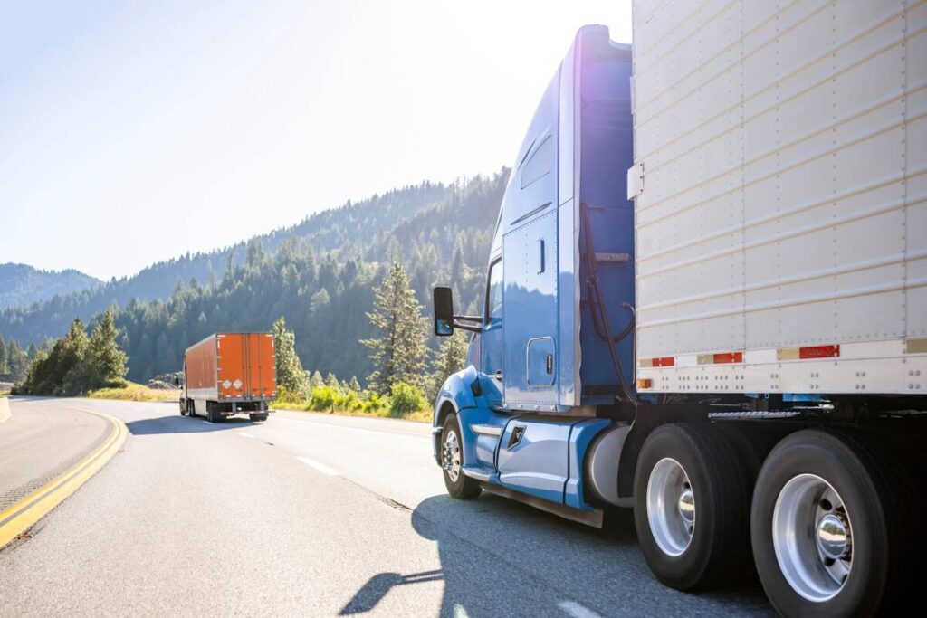 A blue semi truck with a trailor drives on the highway. Photo: Getty Images Plus