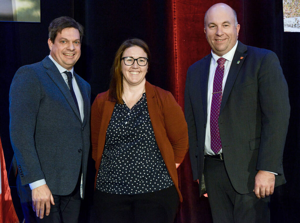 Greg Hannam, left, and Drew Spoelstra, Ontario Federation of Agriculture president, present Lyndsay Dykeman with the inaugural Peter Hannam Leadership Award at the organization