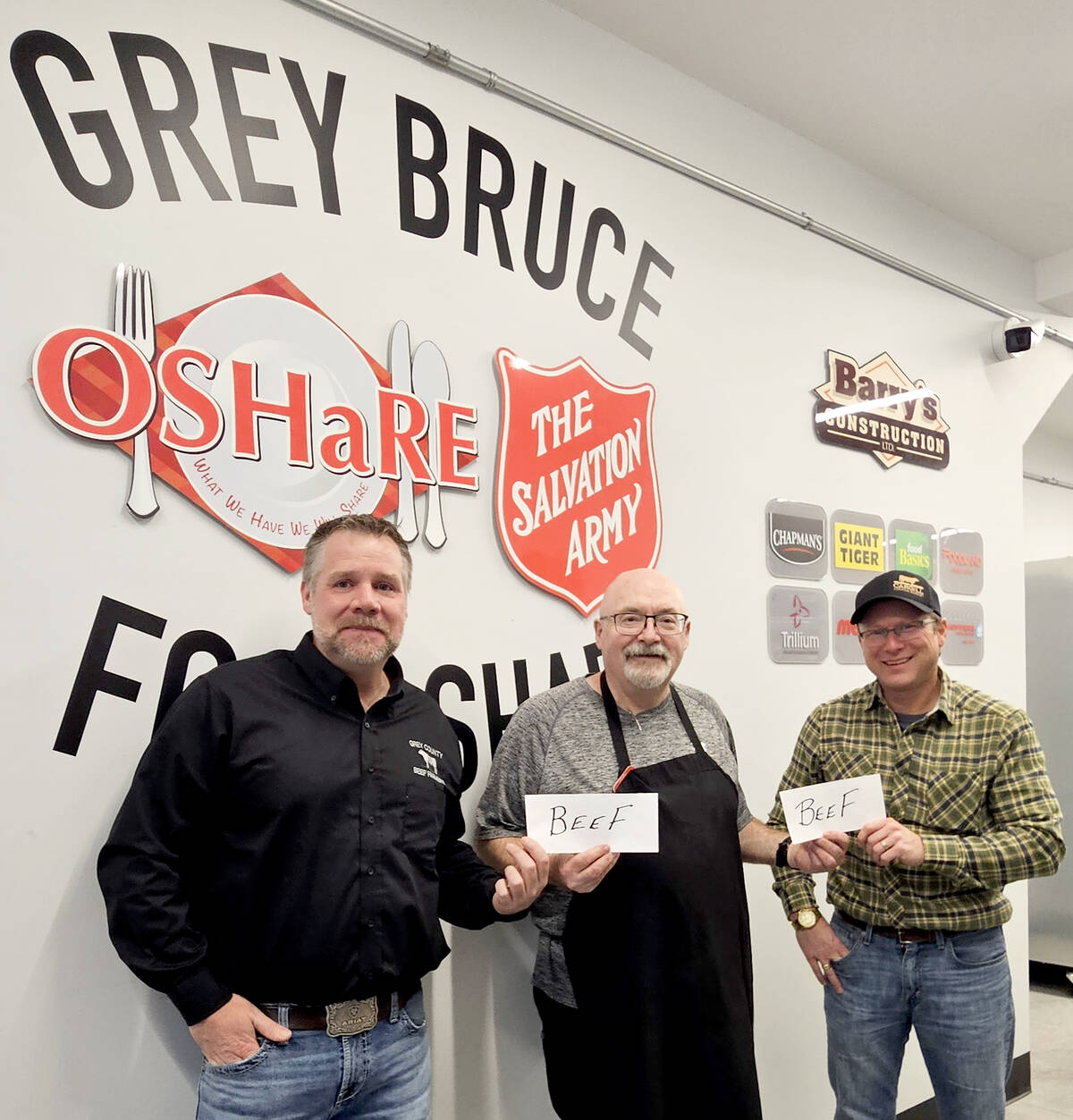 Grey County Beef Farmers Association president Matt McKinnon, left, and Bruce County Beef Farmers president Calvin Anstett, right, beef up Grey Bruce Food Share volunteer Pat McDonough's, centre, day by donating a collective $4,000 to the program. Contributed photo