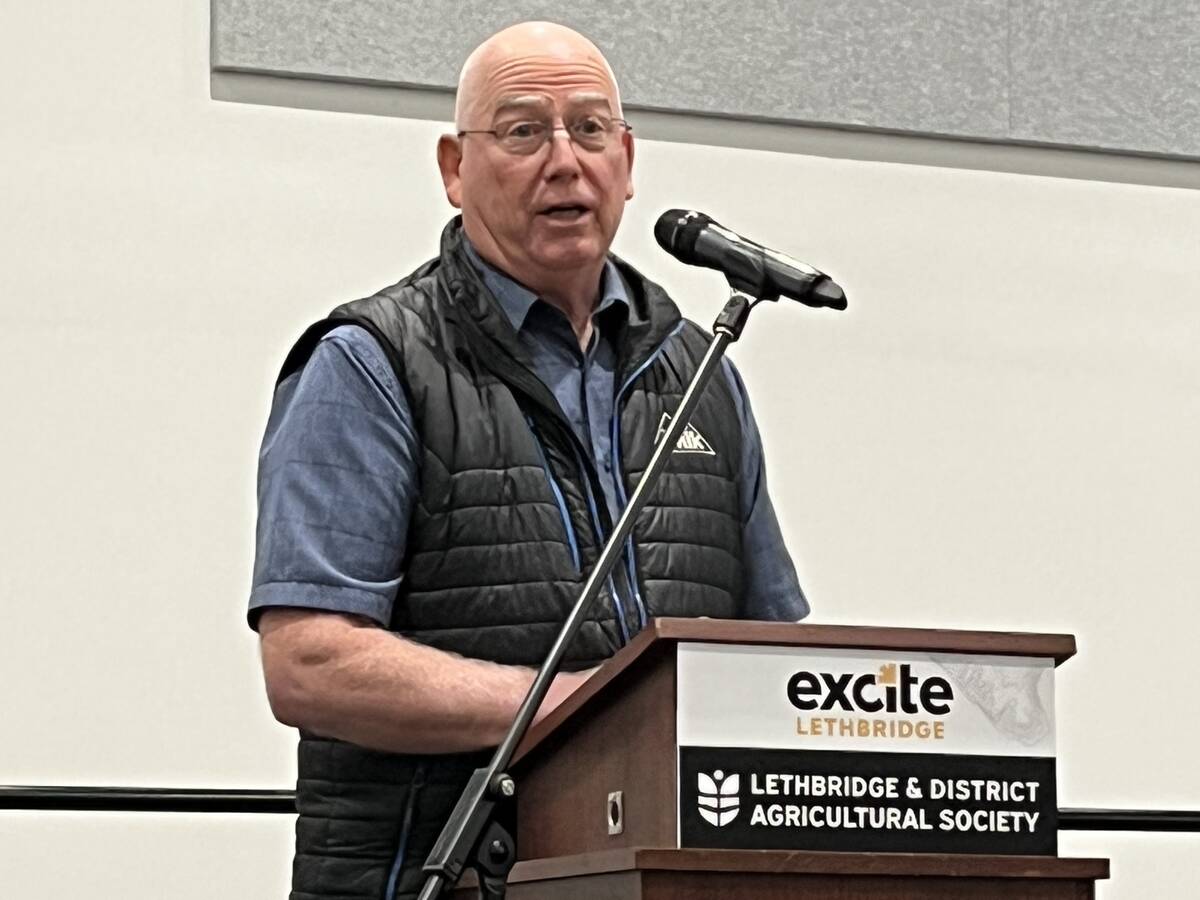 A man stands at a podium speaking during the Alberta Milk fall meeting in October, 2025.