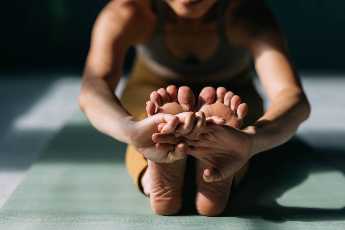 Woman stretching her legs while doing yoga.