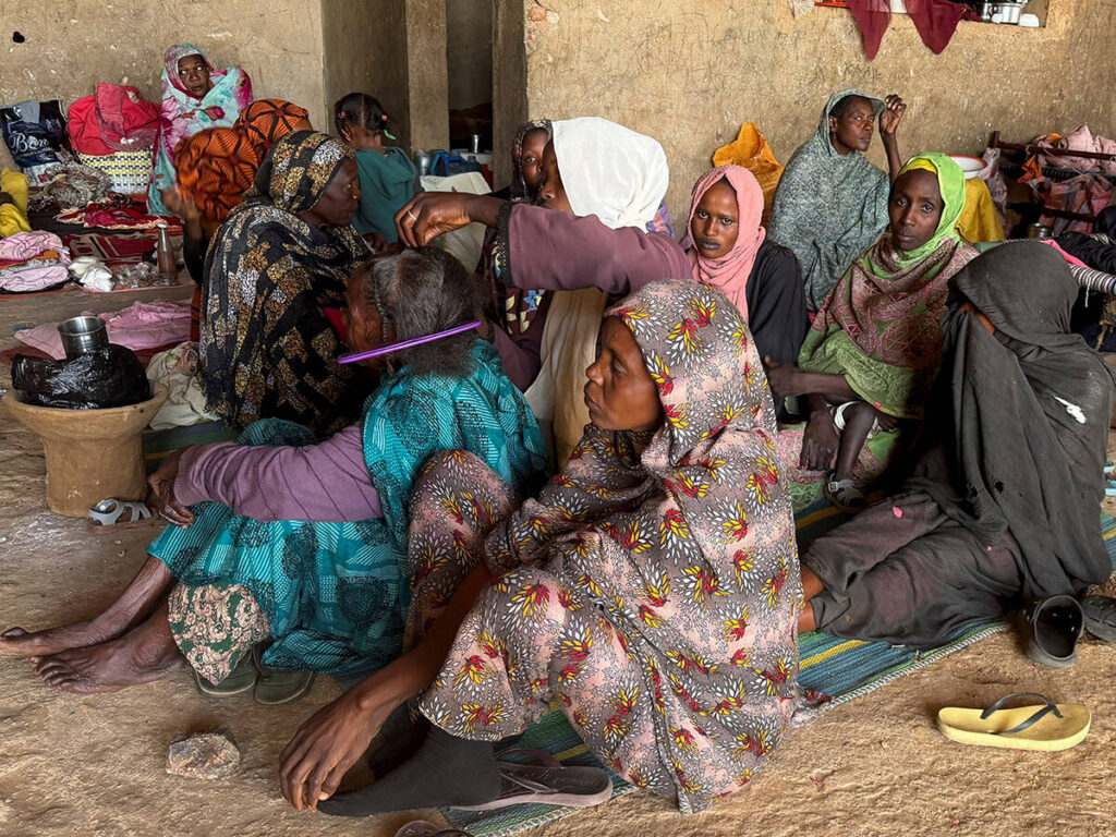 A displaced woman from Dalanj braids her grandmother