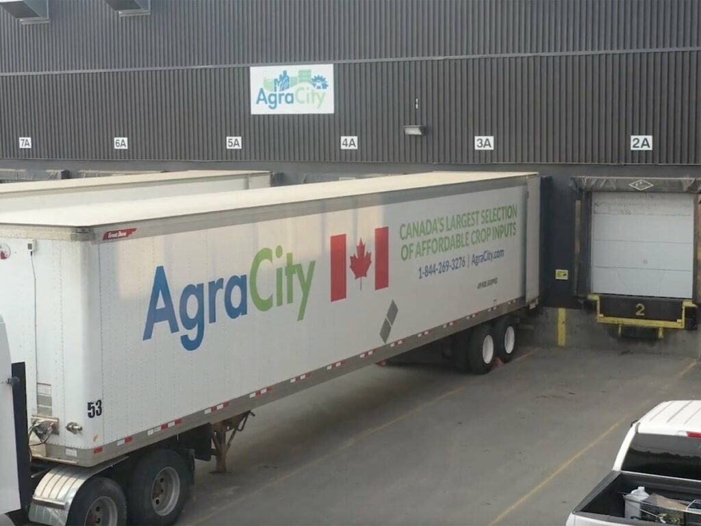 A semi trailer belonging to AgraCity is backed up to the loading dock at an AgraCity warehouse.
