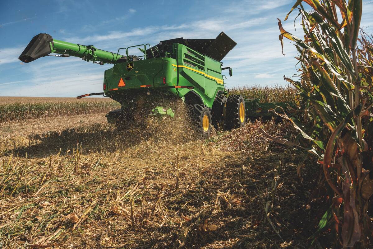 A promotional photo of John Deere's new X9 combine aaas it passes by while harvesting a corn crop.