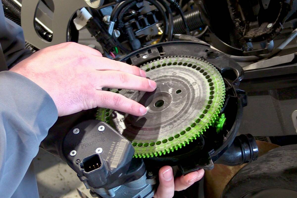A man's hand touches the seed disc in a planter during a demonstration of what to do to get your planter ready for spring work. Photo: Greg Berg