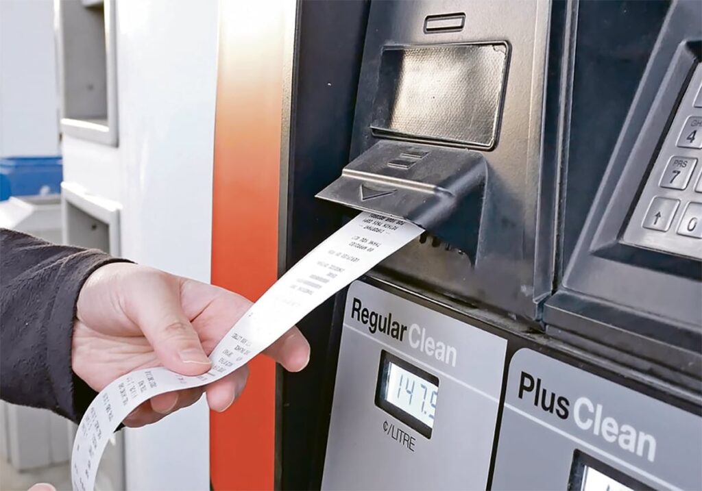 A customer gets a receipt directly from the gas pump after filling up with fuel.