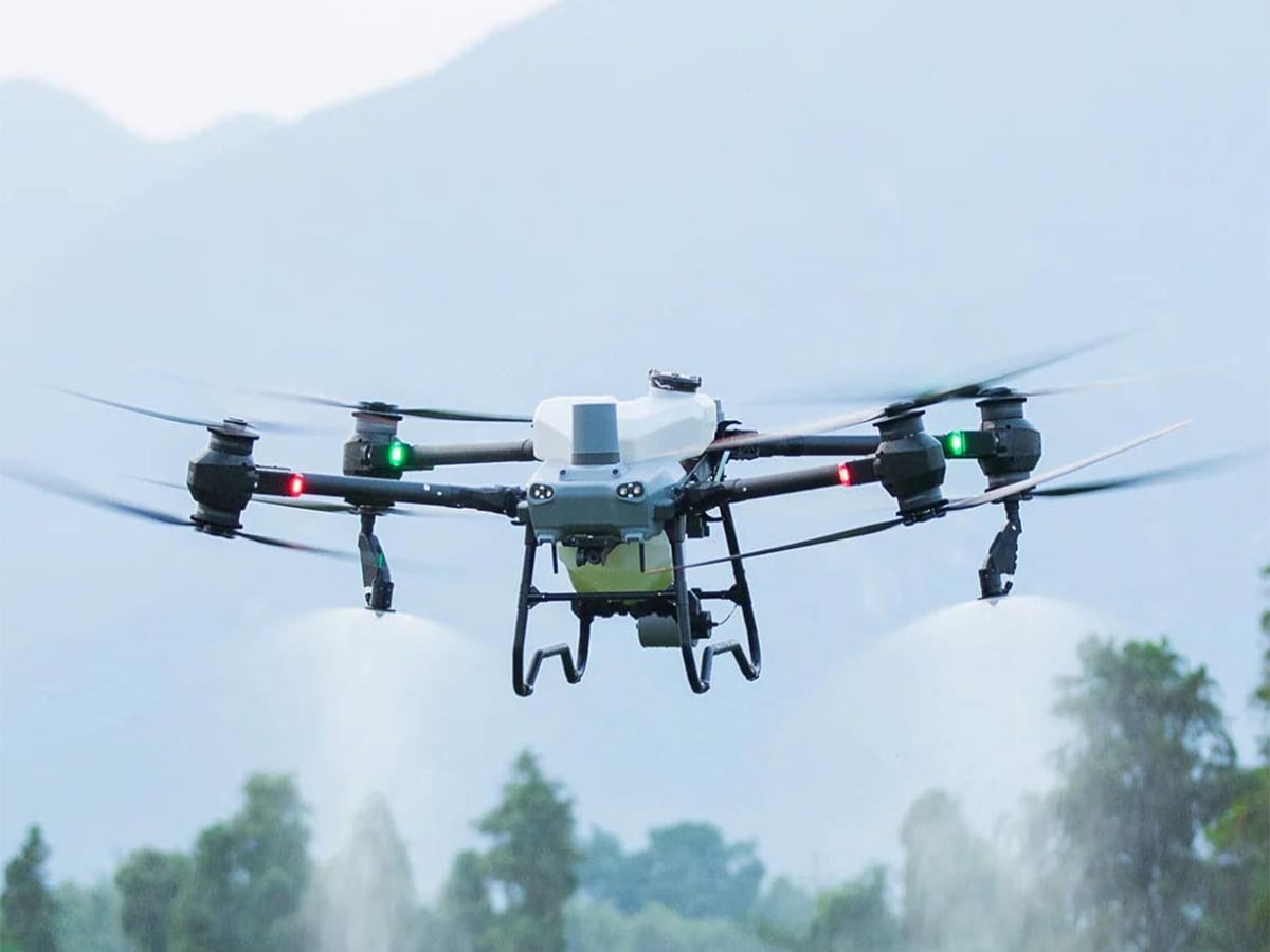 A drone in flight spraying an unseen crop below.