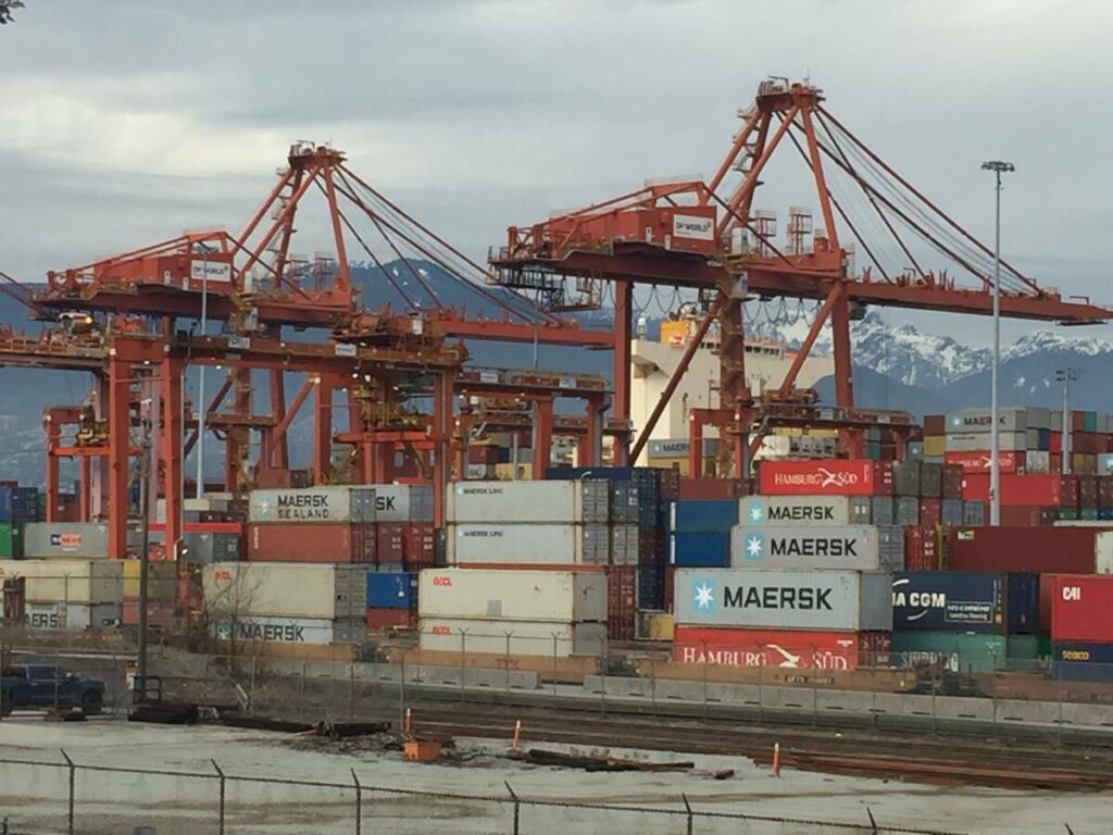 Shipping containers sit dockside beneath the massive gantry cranes used to load them at the Port of Vancouver.