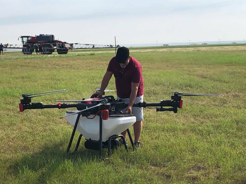 A man filling a drone tank prior to a drone spraying demonstration at Ag In Motion 2024 near Langham, Saskatchewan. Photo: File