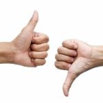 One hand giving the thumb up signal, the other hand giving a thumb down.