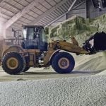 A wheel loader moves fertilizer inside a phosphate production facility.