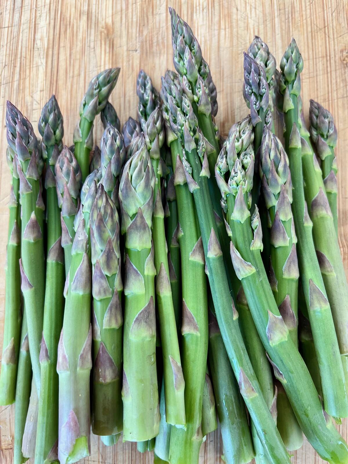 A bundle of fresh asparagus on a table.