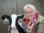 Marina von Keyserlingk poses next to a black and white Holstein dairy calf.